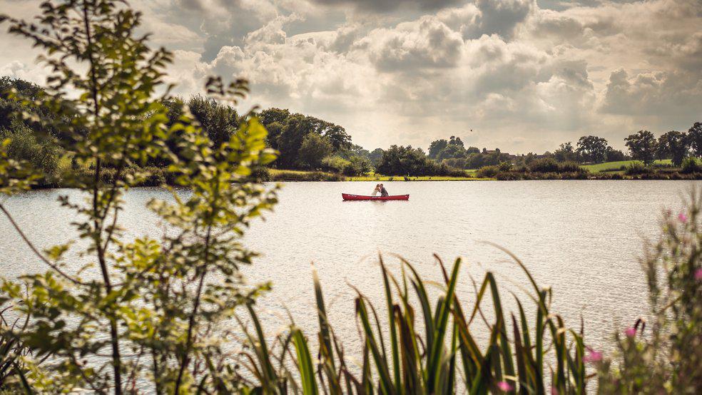 Super adventurous bride & groom take a canoe out on the lake at Sandhole Barn wedding venue