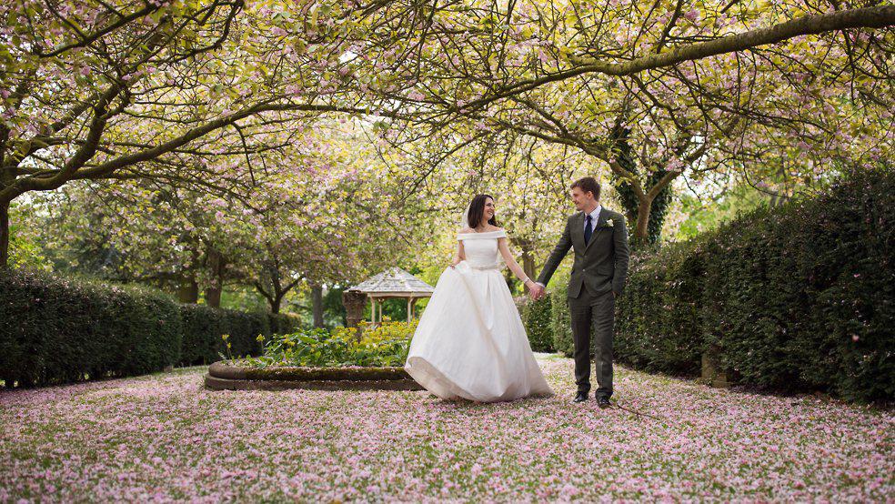 bride and groom walk through the blossum, Hazelwood Castle wedding photos